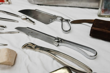 Stainless steel surgical saw, bone snipper and other orthopaedic equipment dating from the early 20th century used for amputations. - obrazy, fototapety, plakaty