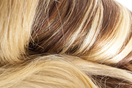 Human hair european hair weft for hair extension. Brown blonde hair texture closeup pattern. Shiny real dyed tail.