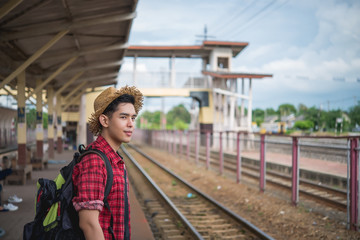 Asian tourist wait train at train station,thailand hipster man go to travel