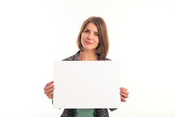 Young woman in green shirt holding sheet of paper and looking at camera. White background is not isolated.