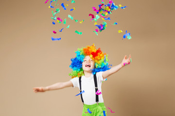 Happy clown boy with large colorful wig. Let's party! Funny kid clown. 1 April Fool's day concept....