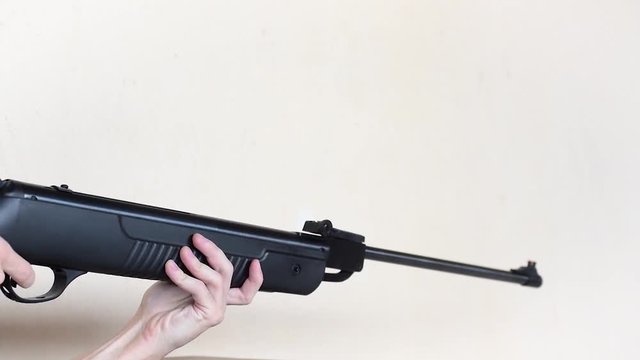 Shooting a break barrel air rifle, pellet gun, aiming and shooting, with shot sound, unidentifiable person, from the side