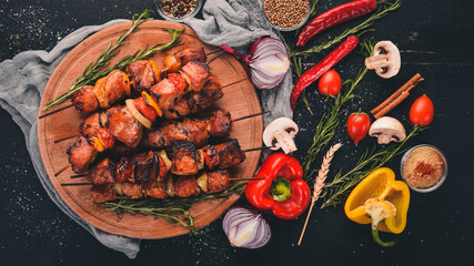 Shish kebab on skewers with onions. On the black wooden table.