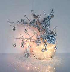 Silver Christmas decoration with fairy lights in the glass vase