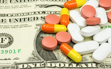 Medicines, capsules and pills lying on bills