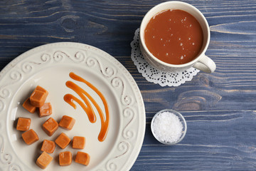 Composition with tasty caramel candies on wooden background