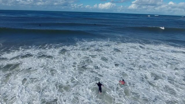 aerial shot of surfers swimming and duck diving
