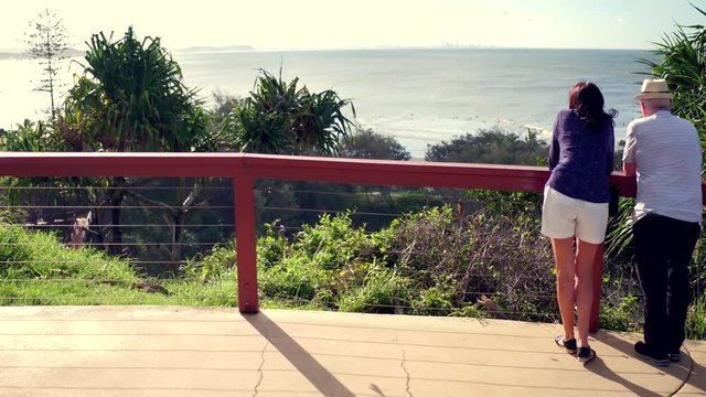 a couple standing looking at ocean view