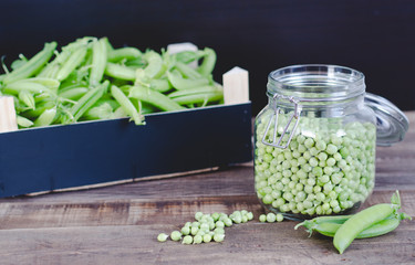 Peas in glass jar on wooden background.