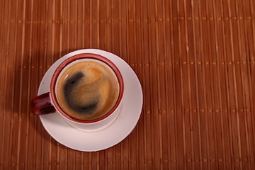 A cup of espresso coffee on a dark wooden background