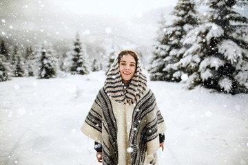 Fototapeta na wymiar Happy young woman having fun in the snow. Happy girl walking in winter time. Snow covered trees in the winter sun light. Snowy pine trees on a winter landscape. snovy trees on winter mountains