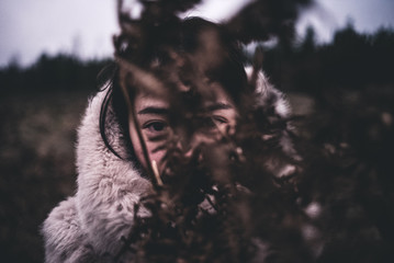 woman hides behind wood