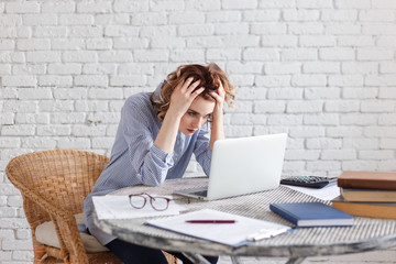 Portrait of tired young business woman with laptop computer