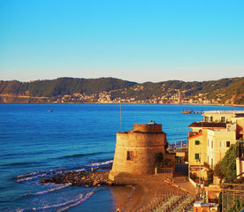 Historic Saracen tower on the beach in the Mediterranean city of Alassio on  the Sunset, a popular resort town on the Italian Riviera, provincia Savona, Liguria, Italy