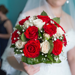 Bouquet from white and red roses in hands of bride