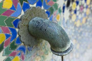 Faucet engraved on a wall of mosaic.