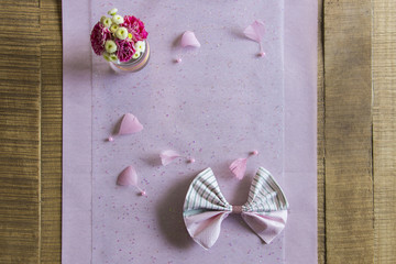 A flower bouquet seen from above and placed on a bright pink tablecloth.