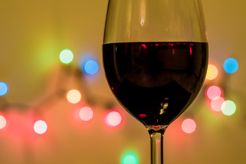 Glass of wine with decorative light in the background