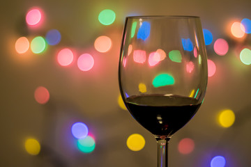 Glass of wine with decorative light in the background