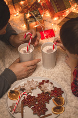 Father and son laying under christmas tree.