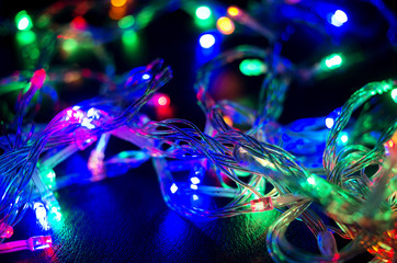 Fototapeta premium A colorful background with glowing Christmas garland. Selective focus.