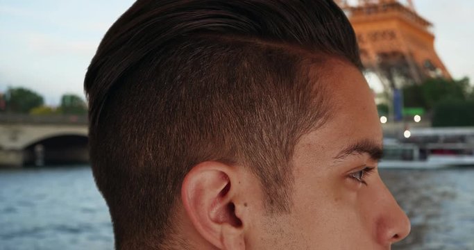 Close up of Latin male with trendy undercut standing near Eiffel Tower