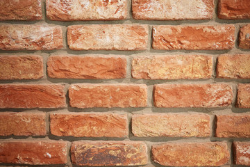 The wall is made of red brick. 