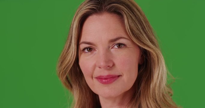 Close up of middle aged Caucasian woman on green screen. On green screen to be keyed or composited.