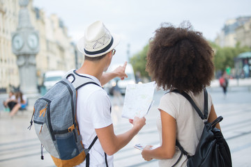 happy tourists searching location together and pointing