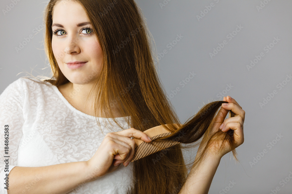 Wall mural Happy woman brushing her hair