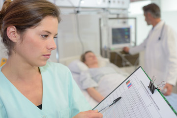 Nurse looking at chart on clipboard