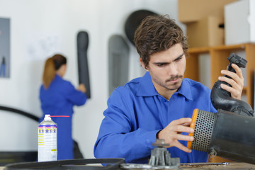 apprentice mechanician manipulating part