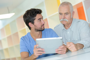 senior and young working together on a project in office