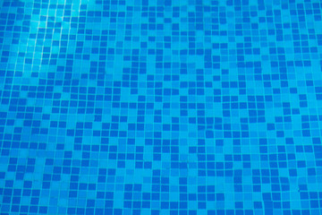Blue abstract mosaic tiles at the bottom of the swimming pool, background.