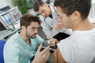 Fototapeta premium young male nurse giving intravenous therapy to patient