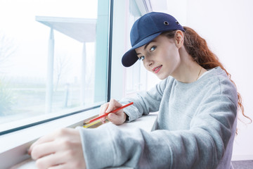 woman measuring the window pane