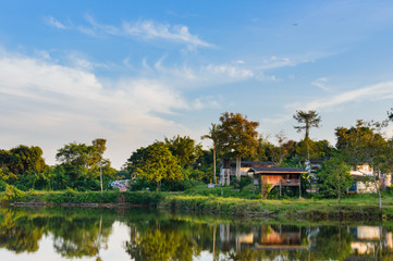 Wooden houses in countryside near the lake with mirror reflection in water