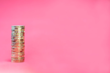 Stacked Pound Coins on Pink Background with Negative Copy Space - obrazy, fototapety, plakaty