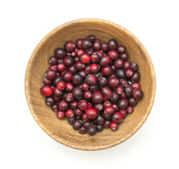 Cranberries in a wooden bowl isolated on white background top view.