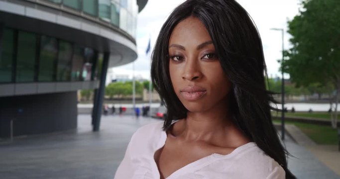 Black woman stares with determination while in London in front of city hall
