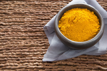 Turmeric in the bowl on wooden background - Cúrcuma