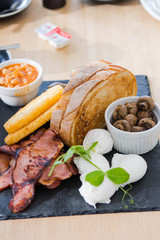 big breakfast meal consist of bread, ham, hashbrown, beans, mushroom and poach eggs