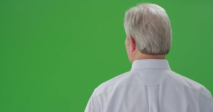 Mid aged male caucasian looking faced at a green screen