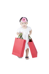 Cute girl carrying shopping bags on studio