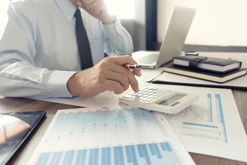 Businessman work with computer on table in office work with paper graph chart