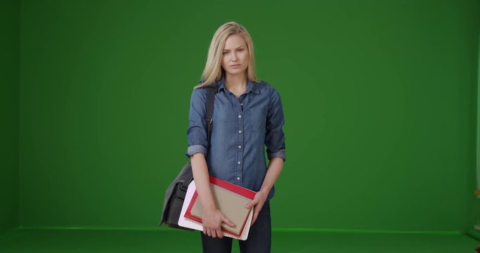 Charming young female student on her way to class on green screen. On green screen to be keyed or composited.