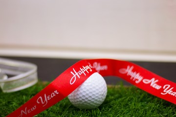 Golf ball for party is on green grass , idea for party invitation 