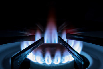 Blue flame of the gas stove in the dark, close-up