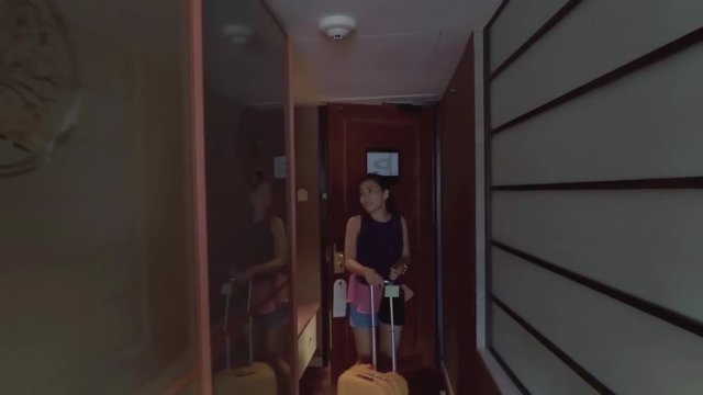 
Singapore. December 11, 2017: Happy young woman arriving in five star hotel room while carrying her suitcase at Marina Mandarin Hotel Singapore
