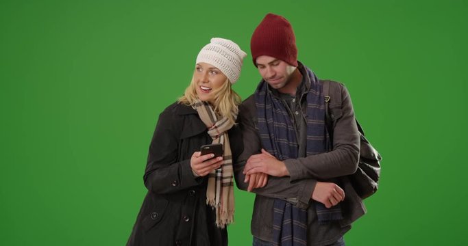 Happy millennial couple figuring out where to eat on green screen. On green screen to be keyed or composited. 